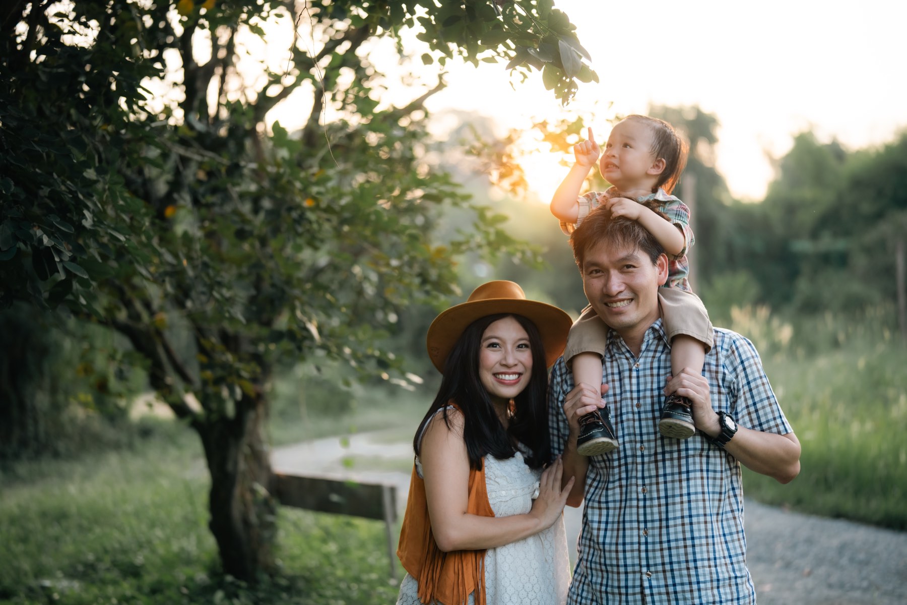 A family walking a tree-lined path at golden hour