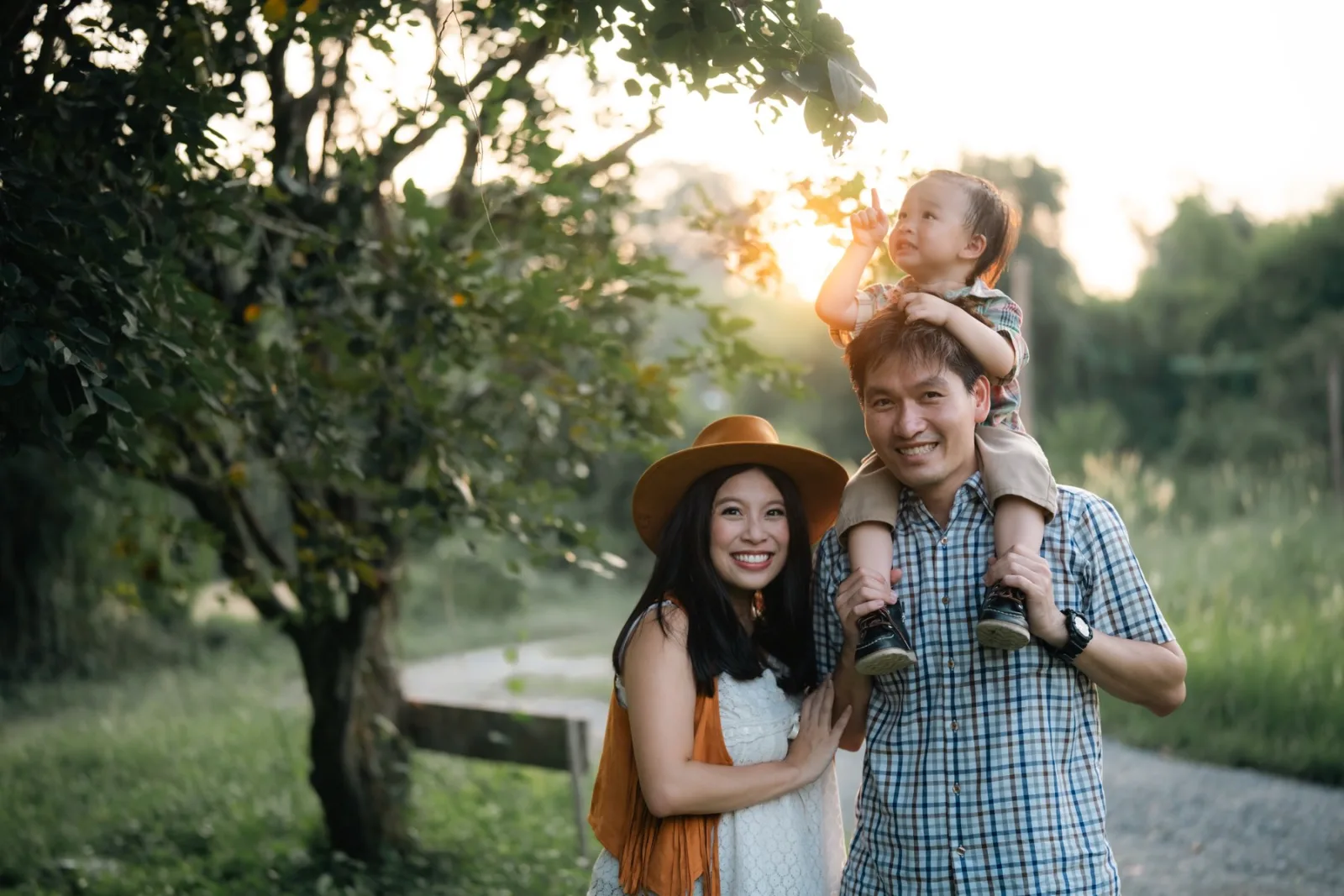 A family walking a tree-lined path at golden hour